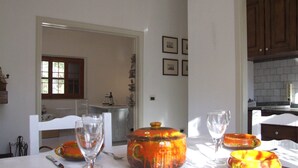 A dining area with a table set for two, featuring orange ceramic dishes and clear wine glasses. - Apartment- Rosa 4+2 - Two Bedroom Apartment, Sleeps 6 (Val Canina)