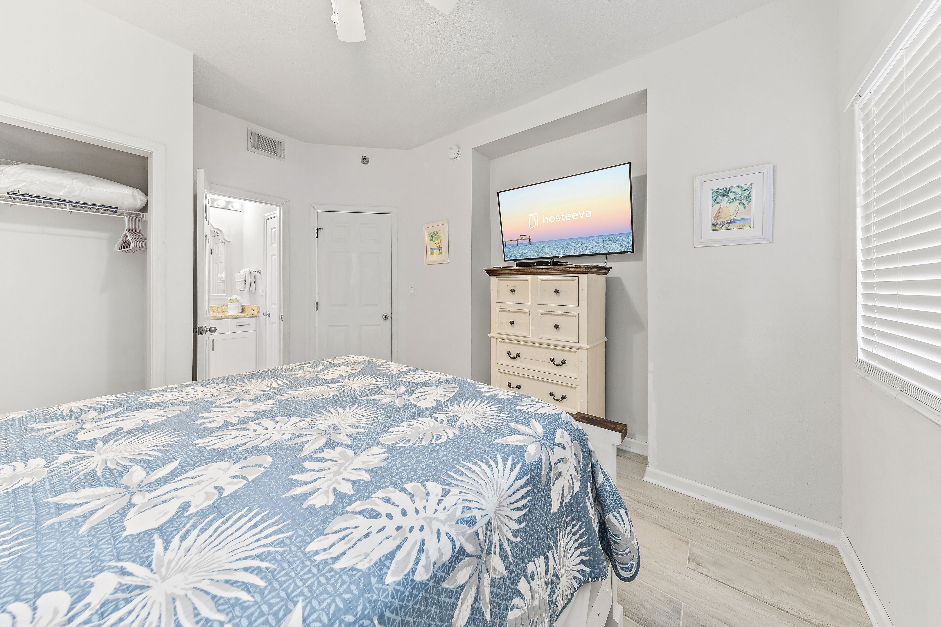 A bedroom with a bed, a television, a dresser, and a closet.