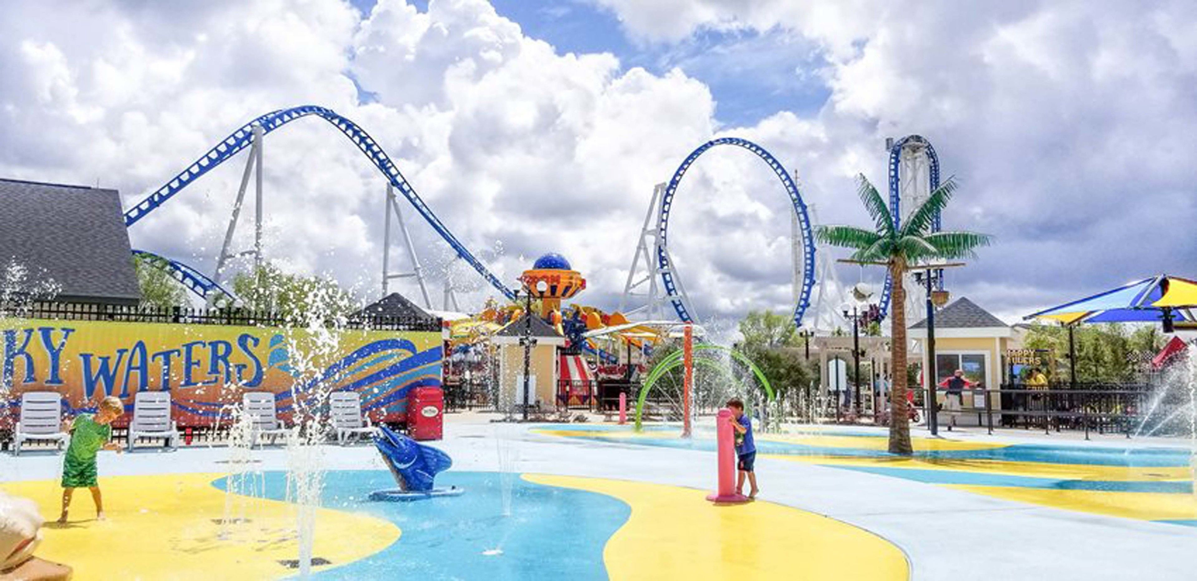 A water park with a roller coaster, water slides, and a splash pad.