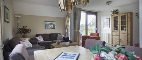 Ein Wohnzimmer mit einem Holzesstisch, einer Couch und einem Schrank.
