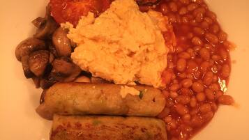 Un plato de comida con frijoles, salchichas y tomates.
