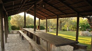 A covered picnic area with stone flooring and wooden benches. - Dante/Pino - Two Bedroom Apartment, Sleeps 6 (Tocco da Casauria)