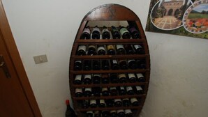 A wine rack with multiple bottles, a door, and a wall with a picture. - Dante/Pino - Two Bedroom Apartment, Sleeps 6 (Tocco da Casauria)