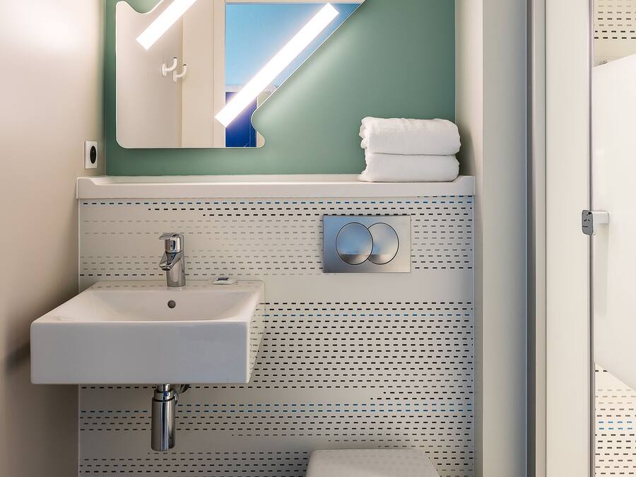 A bathroom with a white sink, a toilet, and a shower area.
