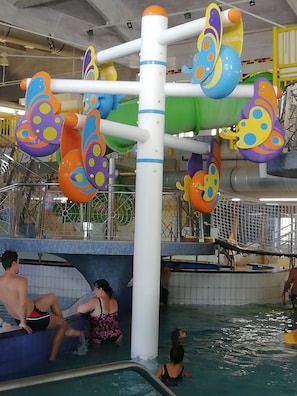 An indoor water play area with colorful butterfly-shaped water features and a pool with people around. - Cedar  Apartment 2 - One Bedroom Apartment, Sleeps 4 (Zalakaros)