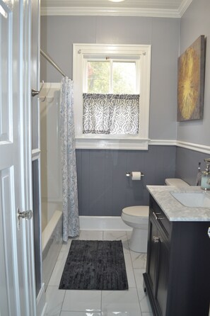 A bathroom with a bathtub, toilet, and sink. - Starfish House Savannah Fort Stewart GA (Richmond Hill)