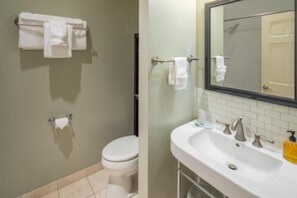 A bathroom with a toilet, sink, and mirror.