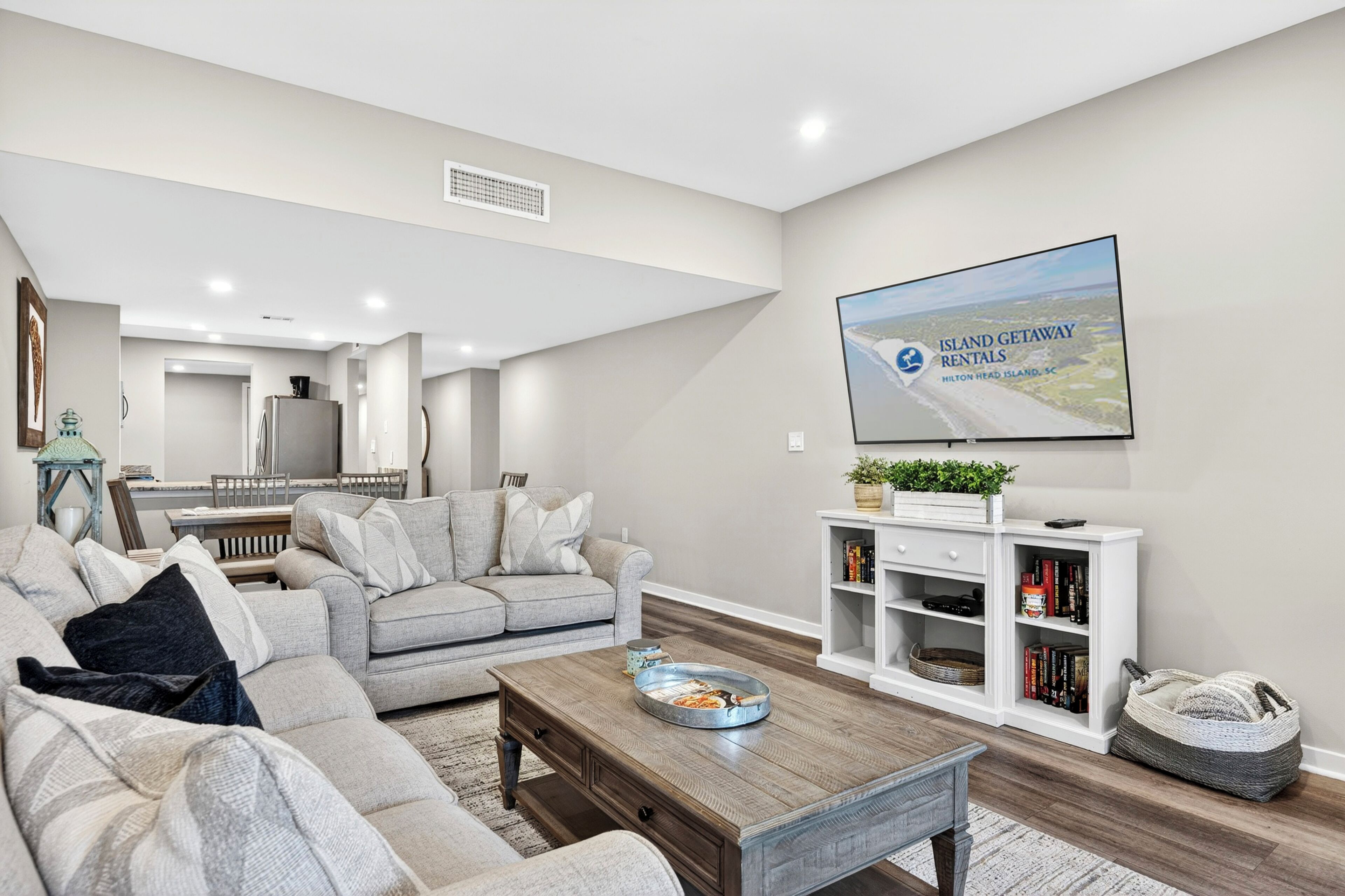 A modern living room with a sofa, coffee table, and a television displaying 'Island Getaway Rentals.'