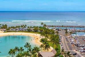 A coastal resort with a sandy beach, a marina, and a parking area.