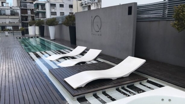 Un espace piscine aménagé sur le toit, avec des chaises longues et un jacuzzi.