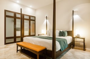Relax in comfort with a large bed, bench, and nightstand, surrounded by natural light and stylish storage.