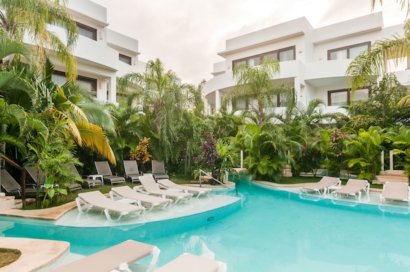 Relax by the pool surrounded by lush tropical vegetation and modern architecture.