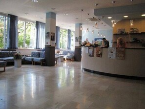 Eine großzügige Lobby mit Empfangstresen, Sitzgelegenheiten und großen Fenstern.