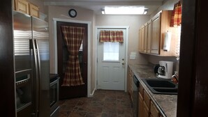 A compact kitchen with a refrigerator, oven, and coffee maker.