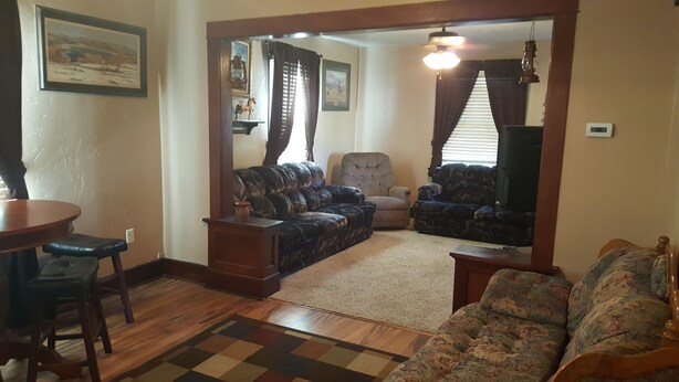 A living room with a sofa, armchair, and a television.