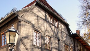 A historic building with a cobblestone street, a bench, and a street lamp.