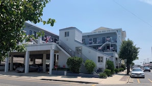 Un immeuble à plusieurs étages doté d’un garage, d’un escalier et d’une enseigne indiquant « Key Colony Condos ».