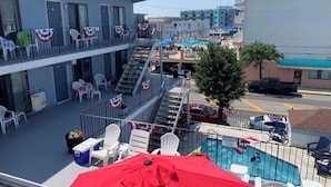 Un bar situé sur le toit, avec une terrasse, une piscine et un escalier menant à une plateforme supérieure.