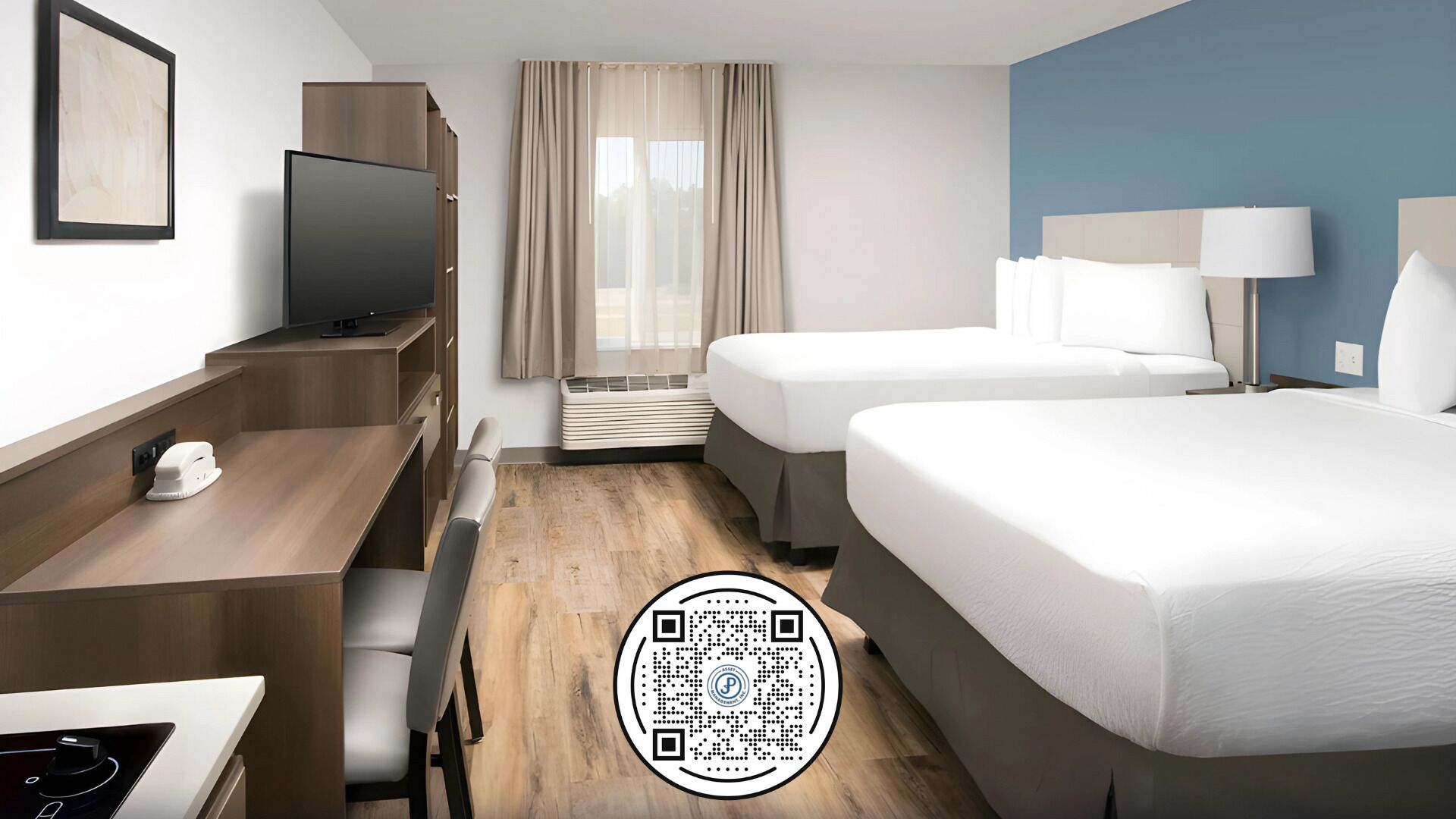 Habitación de hotel con dos camas, un escritorio, un televisor y una ventana con cortinas.