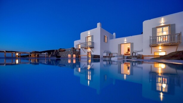 A modern white building with a pool, stone steps, and a balcony. - Villa Juliet (Mykonos)