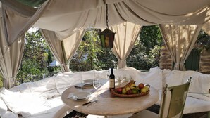 A round table set for two with a bottle of wine, a fruit basket, and a candle. - La Quercia-Erica - One Bedroom Apartment, Sleeps 5 (Val Canina)
