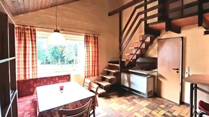A compact kitchen with a dining area, a staircase, and a view of the outdoors. - Typ Biberbau - Three Bedroom Resort, Sleeps 6 (Bestwig)