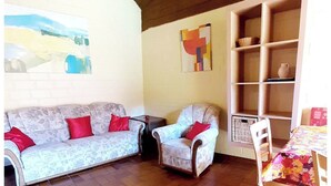 A living room with a sofa, armchairs, a table, and a tiled floor. - Typ Biberbau - Three Bedroom Resort, Sleeps 6 (Bestwig)