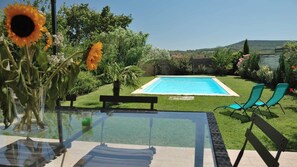 A poolside view with a clear sky, a pool, green lawn, and a table with chairs. - House with private pool, not shared between Vaison la Romaine and Nyons (Saint-Maurice-sur-Eygues.)