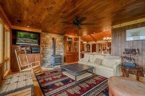 Cozy living area with a stone fireplace, flat-screen TV, and comfortable seating.
