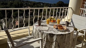 A balcony with a table set for breakfast, overlooking a coastal view. - Sublime ocean view Access to all swimming pools offered. Comfortable and clean (Saint-Raphaël)