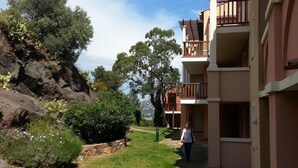 A building with a balcony and a pathway leading to it. - Sublime ocean view Access to all swimming pools offered. Comfortable and clean (Saint-Raphaël)