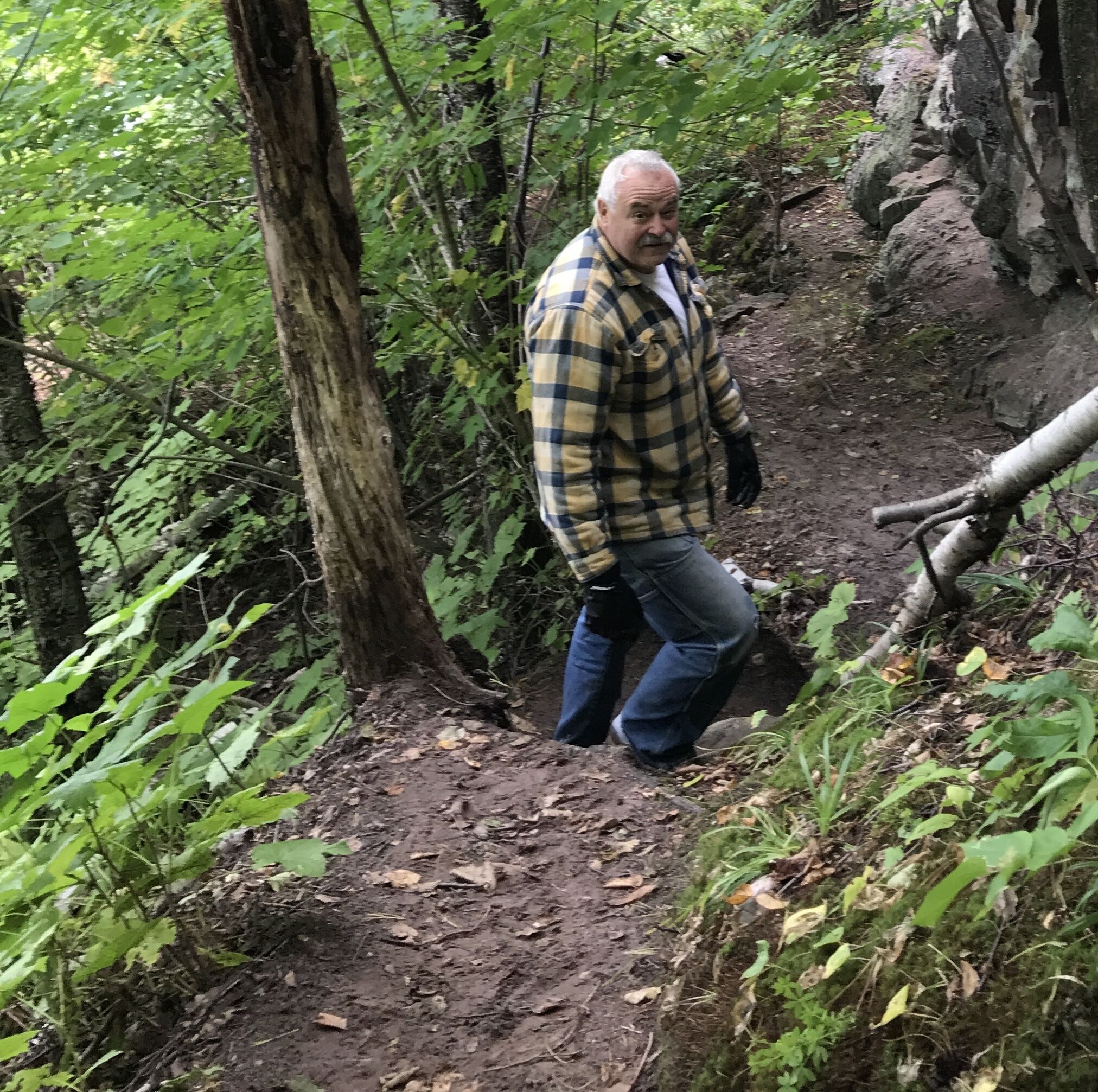 Un hombre caminando por un sendero en el bosque.