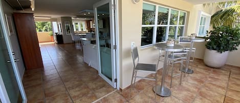 Cocina amplia con comedor, ventanas grandes y una planta en maceta.