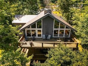 A house with a large deck, multiple windows, and a chimney. - Historic Beech Mountain Lodge | Hot Tub | Game Room | Sleeps 19 (Beech Mountain)