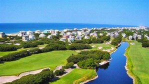 An aerial view of a coastal area with a golf course, a river, and residential buildings. - Fun in the Sun! 3 bdrm/2 Bath Ocean Front Condo with gorgeous views of the Gulf! (Orange Beach)
