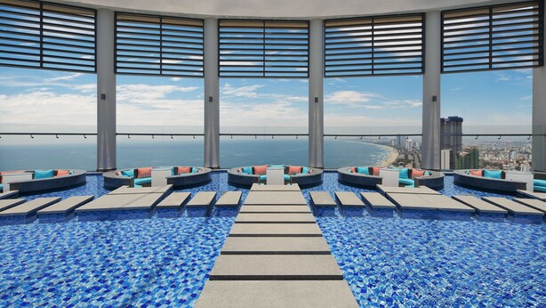Piscina infinita en la azotea con asientos escalonados y vista al océano.
