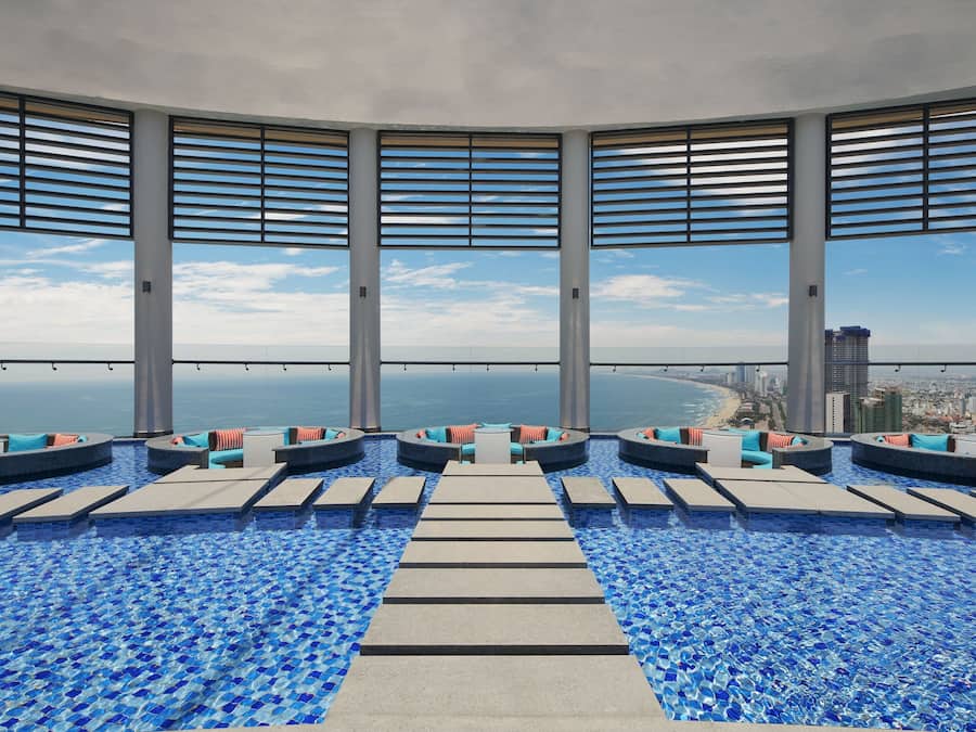 Una piscina al aire libre, sombrillas, sillones reclinables de piscina