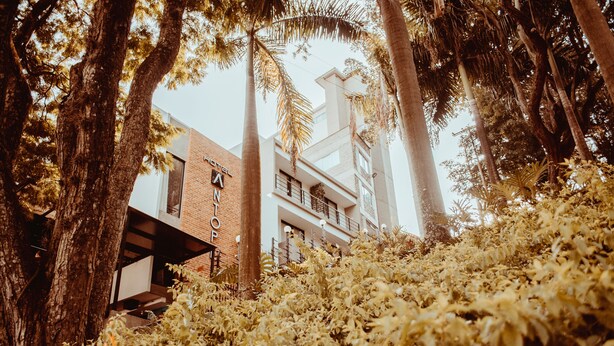 A hotel with a brick facade, a visible sign reading "HOTEL," and a balcony with railings. - Antope - Apartaestudios (Cali)