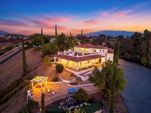 Une maison à deux étages dotée d’un patio, d’une piscine et d’une pelouse bien entretenue.
