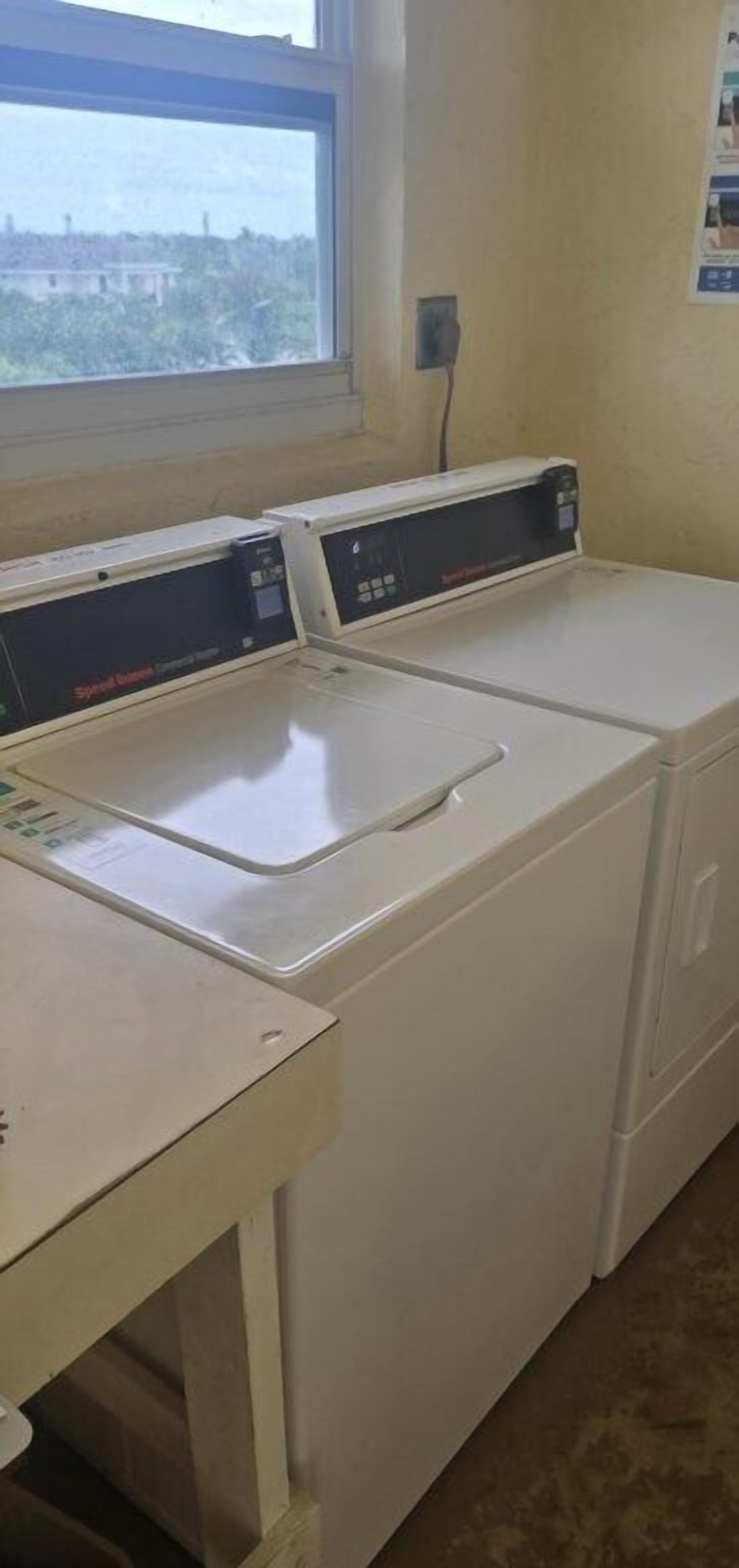 A laundry room with two washing machines and a dryer.