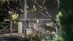 A garden area with a wooden pergola, a white chair, and a white wall in the background. - Piccadilly House Daylesford ~ Walk to main street! (Daylesford)