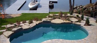 A luxurious villa nestled along the bay upon a rock , breathtaking sunset views