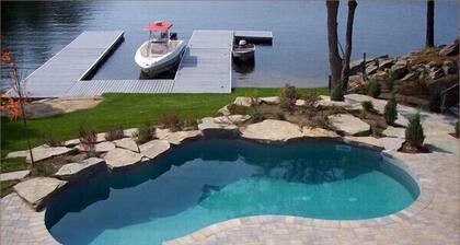 A luxurious villa nestled along the bay upon a rock , breathtaking sunset views