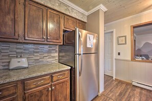 Enjoy a fully equipped kitchen with a refrigerator, toaster, and tiled backsplash, offering a mountain view.