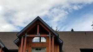 A two-story house with a stone foundation, wooden exterior, and a steeply pitched roof. - Slope Side  Luxury Open Beam Townhome Private Hot Tub - True - Ski-in-out (Golden)
