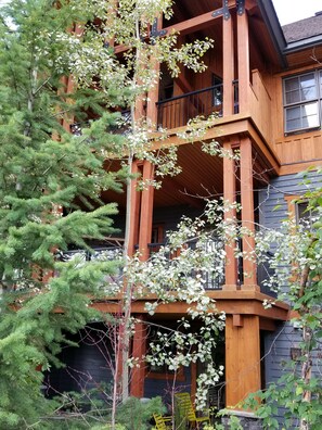 Un immeuble en bois à plusieurs étages, doté de balcons et d’un espace porche.