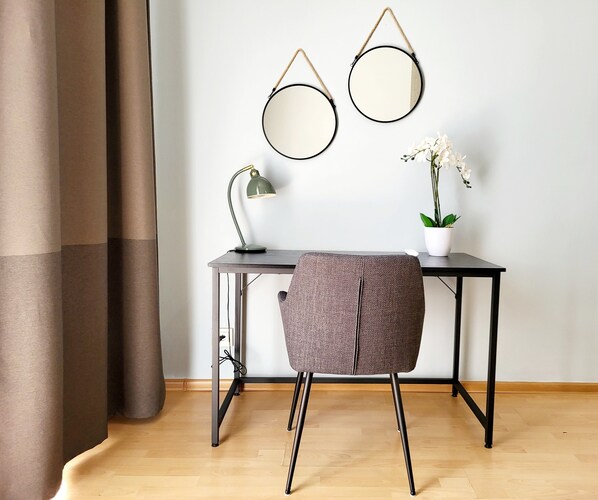 A desk with two round mirrors, a lamp, and a potted plant.
