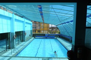 Una piscina interior con vistas despejadas de los edificios circundantes.