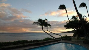 A swimming pool with a view of the ocean and palm trees. - Romantic Beachfront Getaway (Maalaea Bay)
