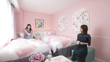 A pink-themed bedroom with two beds, a coffee table with a vase of flowers, and a wall with fashion posters.